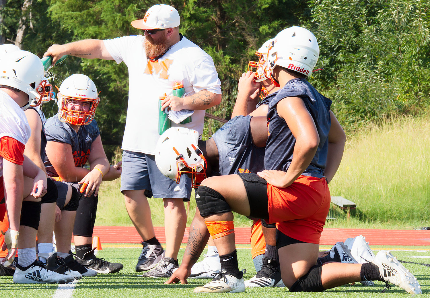 Mineola football players get a water break Monday morning.